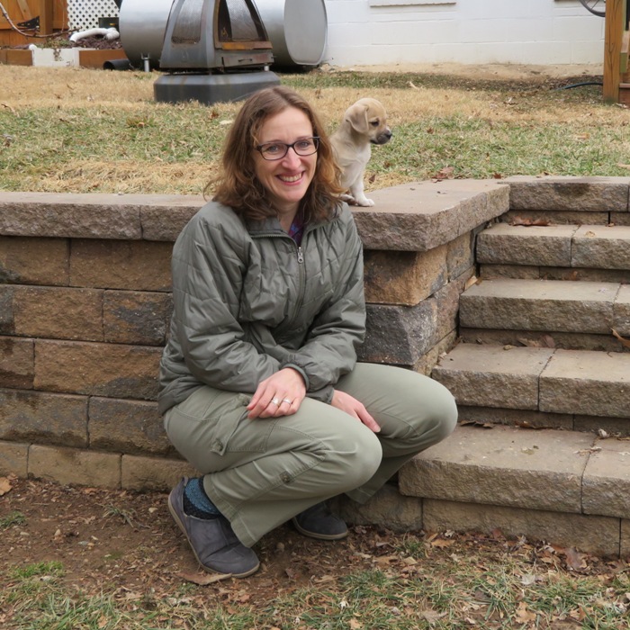 Norma sitting near retaining wall with Daphne at her shoulder