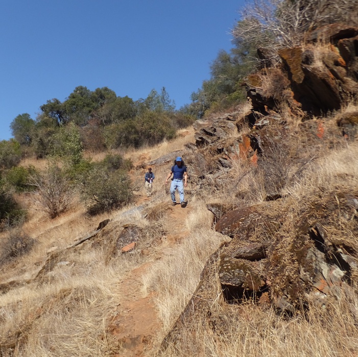 Ken and I walking downhill on trail lined by dry grass