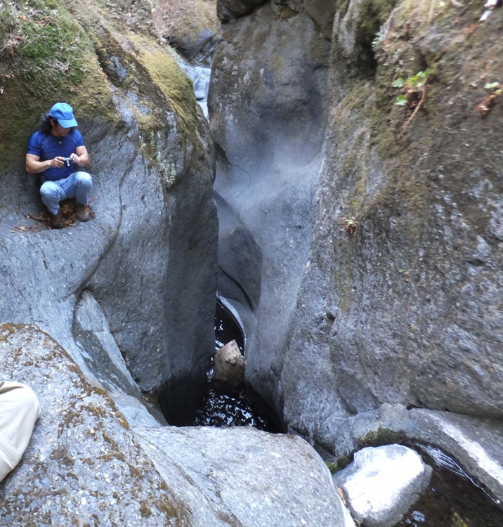 Me sitting on rock ledge above high drop