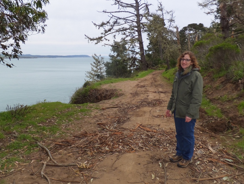 Norma on the trail with the Pacific Ocean behind