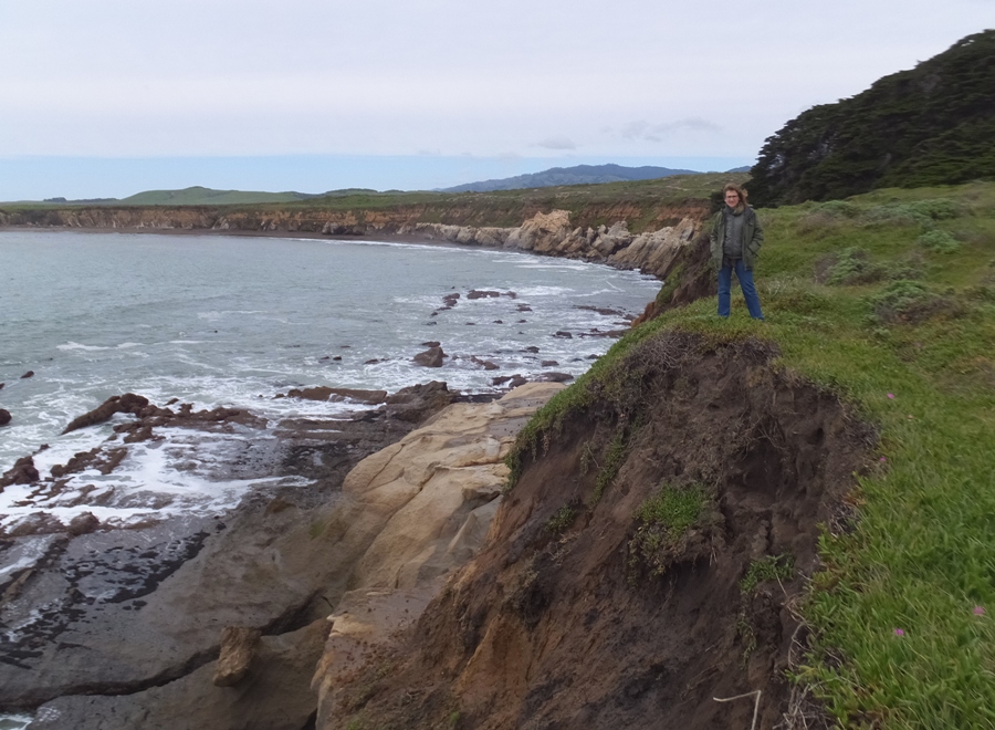 Norma at the edge of a windy cliff by the ocean