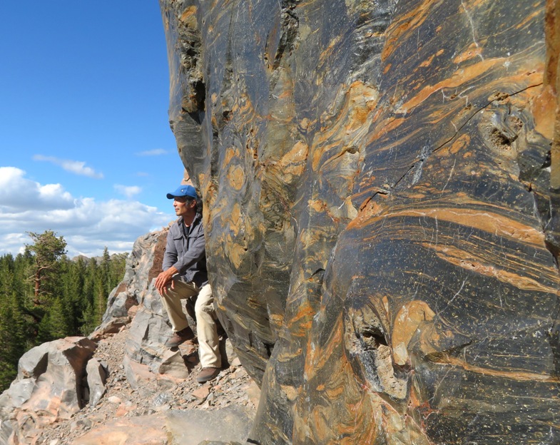 Me looking at the horizon by a cliff of swirled obsidian