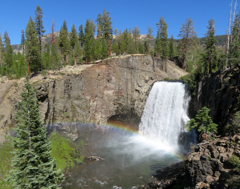 Falls with rock cliff, trees, and rainbow