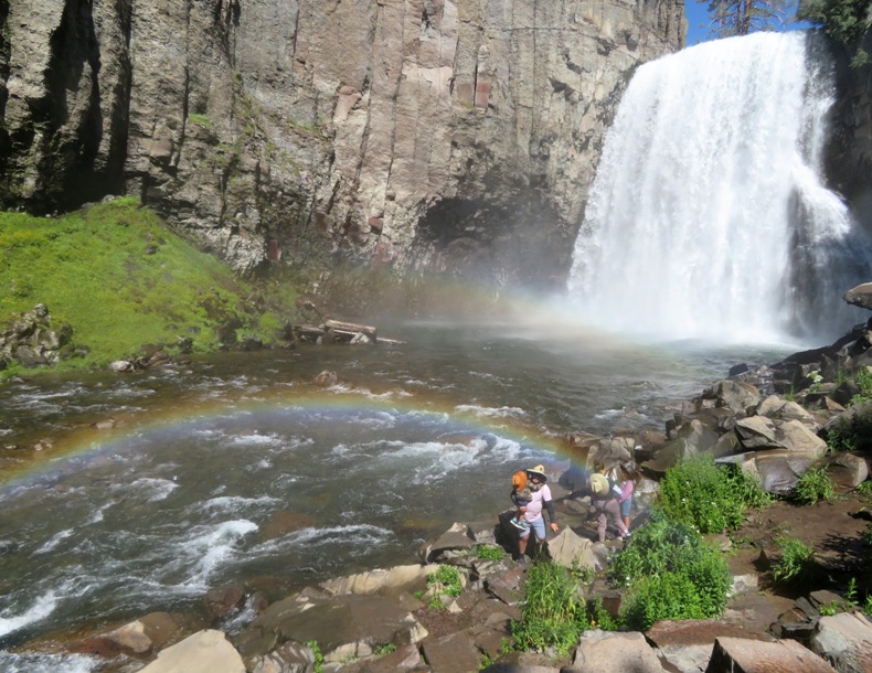 People along the river with a pronounced rainbow