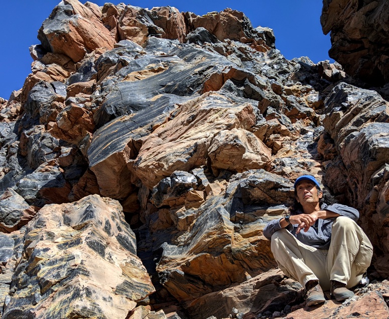 Me sitting below obsidian boulders