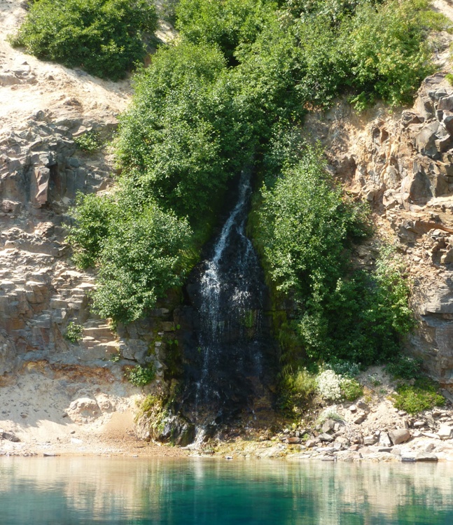 A small waterfall helps keep Crater Lake full