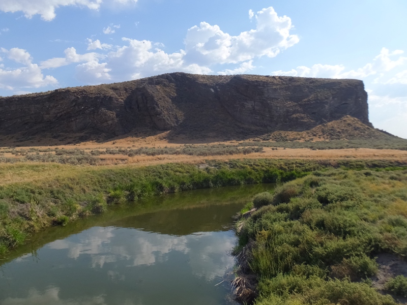 Drainage ditch with towering bluff behind