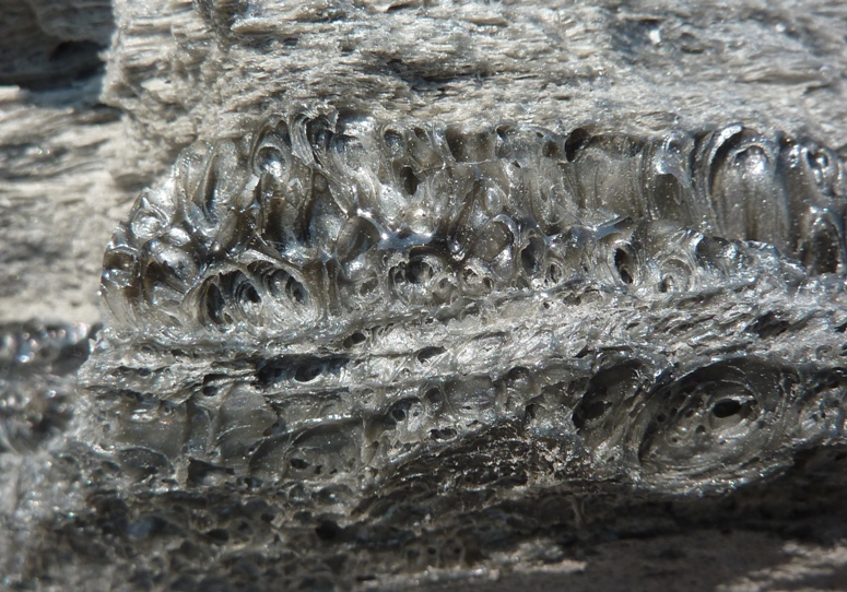 A rock that looks like a piece of glass with bubbles