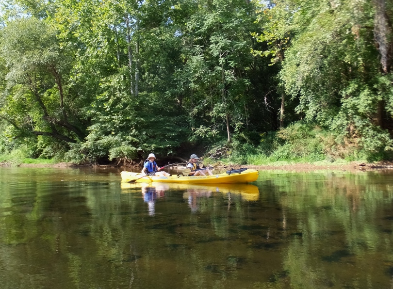 Norma with the blade of her kayak in the water and Janett's resting on her lap