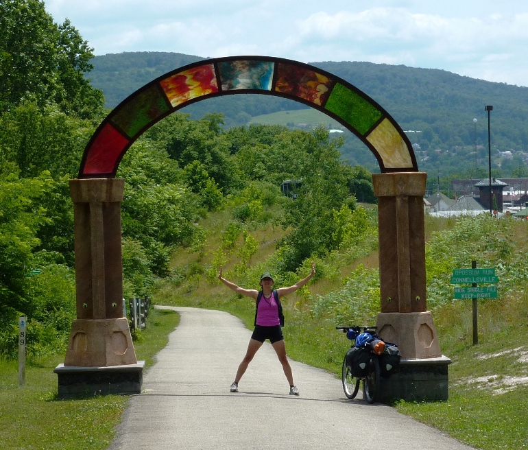 Carmen with arms outstretched under the arch