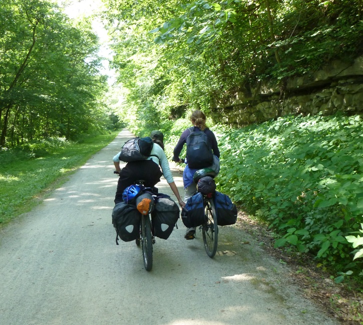 Carmen zipping Norma's pannier saddlebag while both of them ride