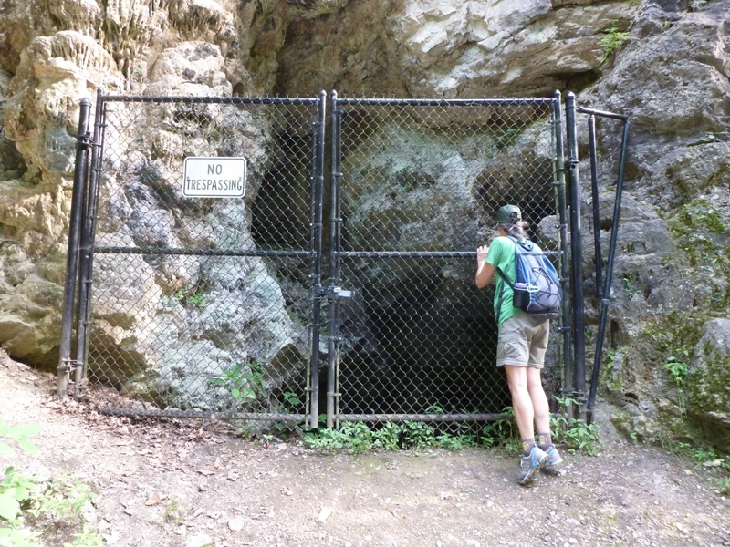 Carmen looking through fence at cave