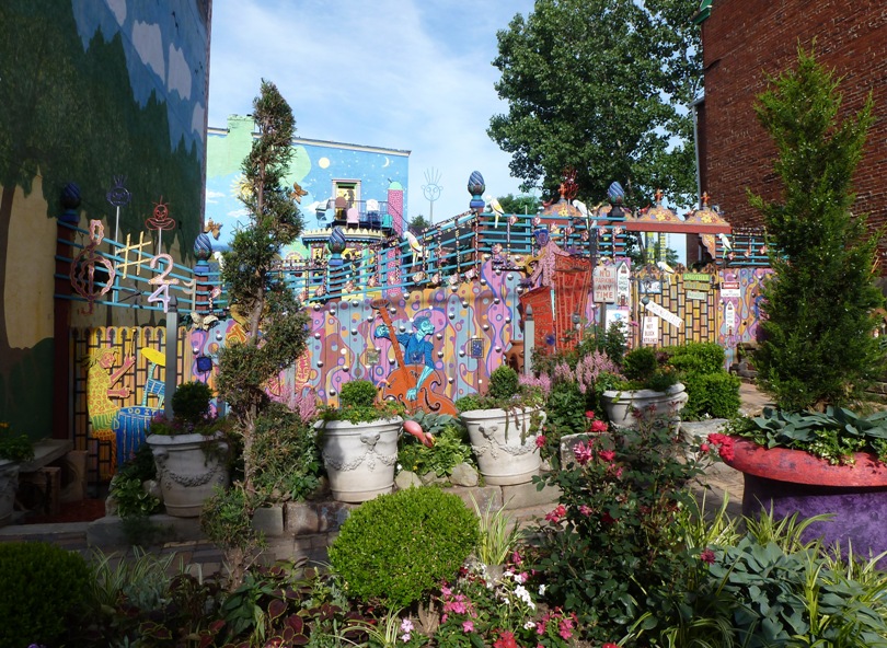 Plants in front of colorful fence