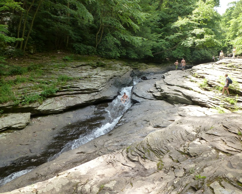 Man going down natural waterslide