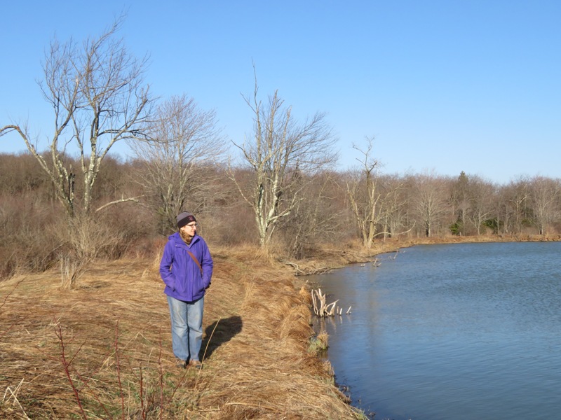 Norma standing by a pond