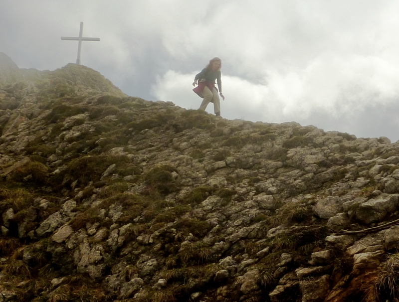 Norma walking down on the ridgeline with a cross behind