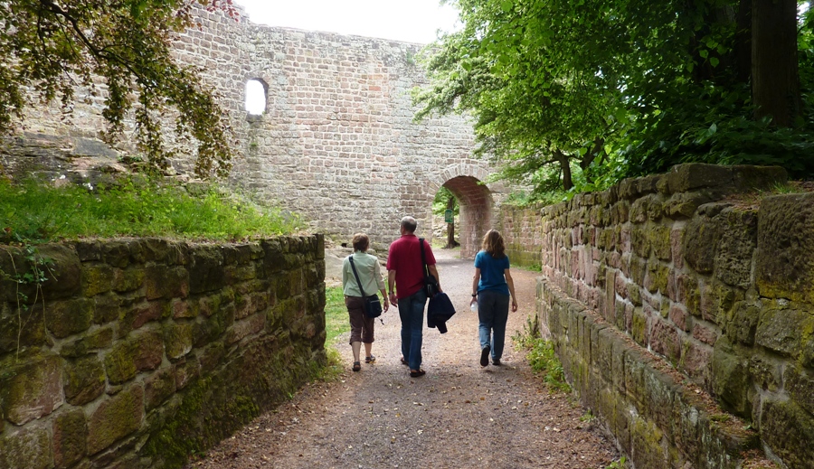 Eric, Beate, Norma walking towards stone-lined entrance to fortress