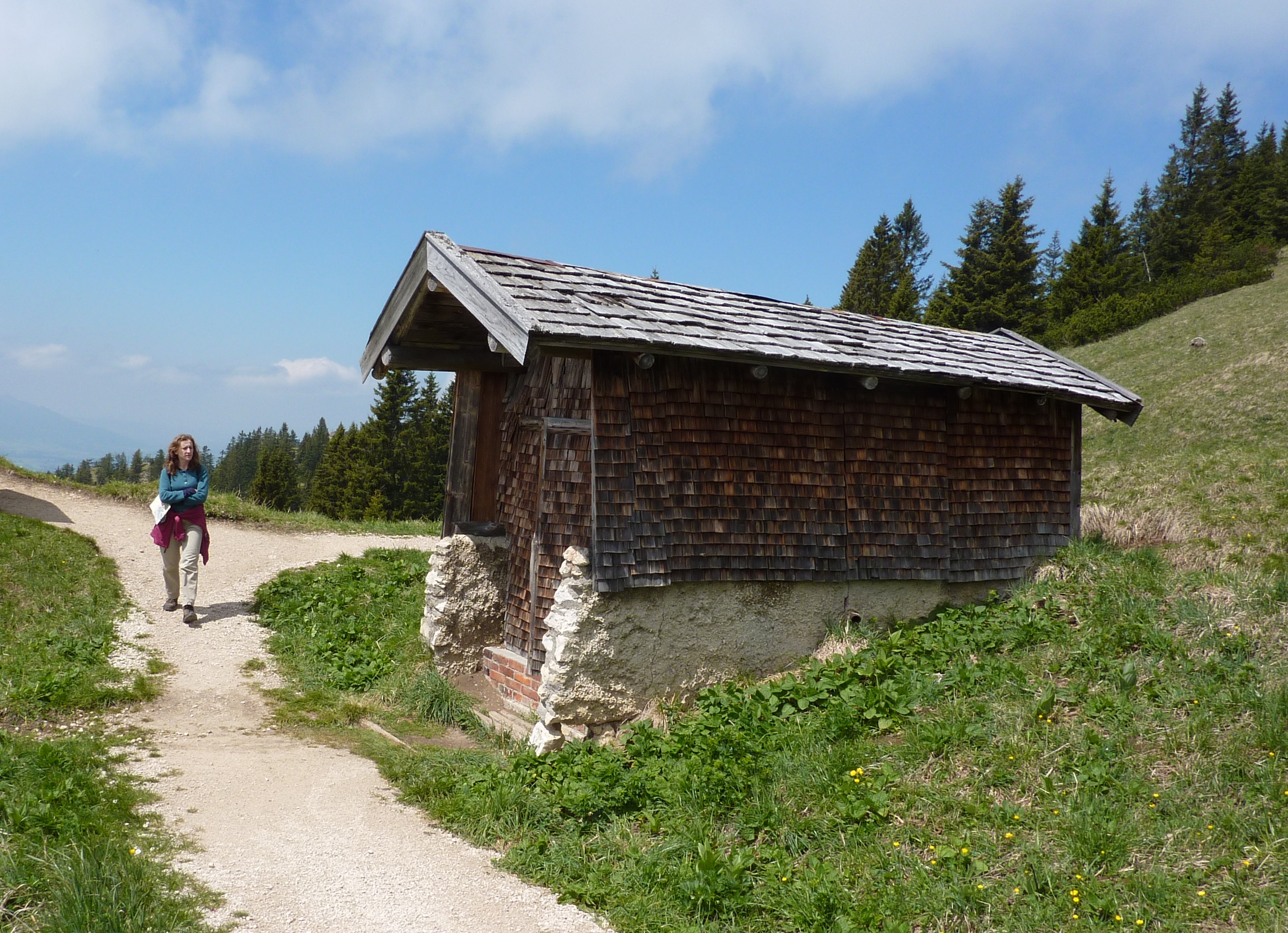 Norma walking down trail past shack