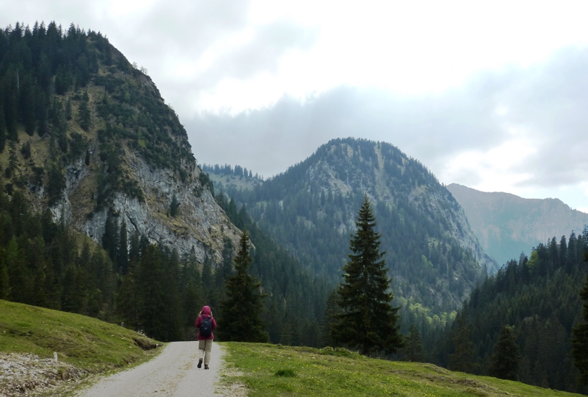 Norma on dirt road with rugged mountains in front of her