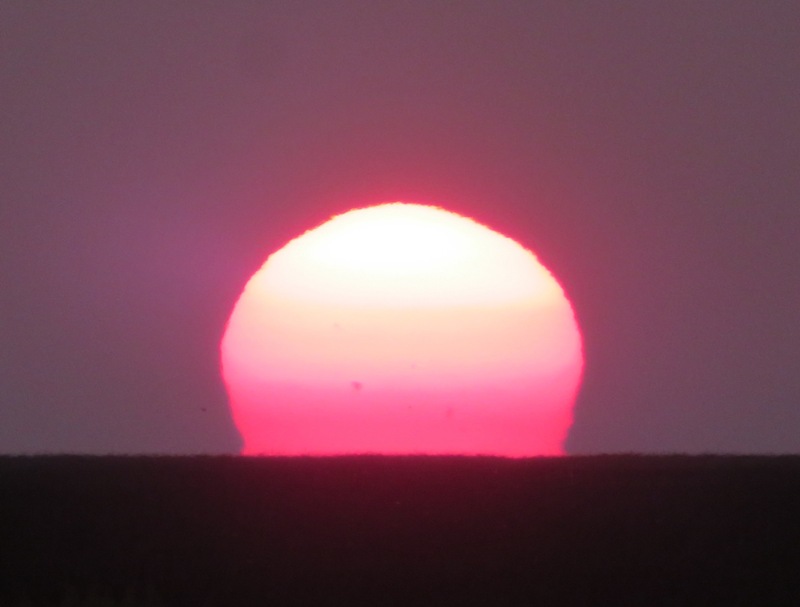 The sun setting, showing shades of yellow, orange, and red