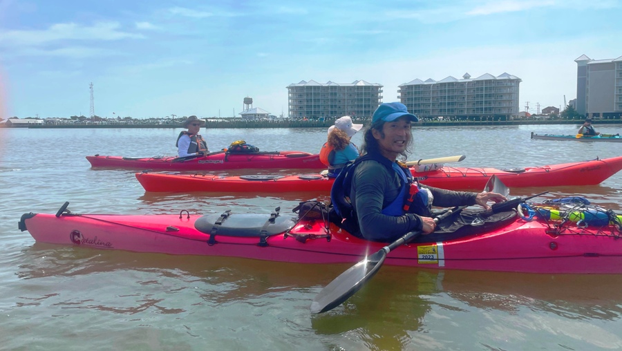 Me in kayak with other paddlers and the town of Crisfield behind us