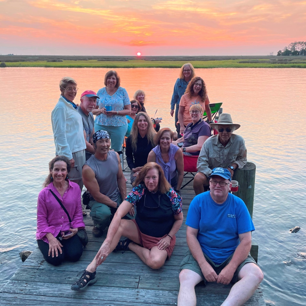 Group on the pier with the setting sun in the background