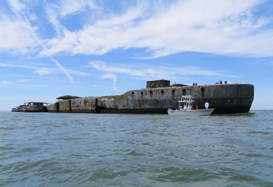 Concrete ship with small boat in front