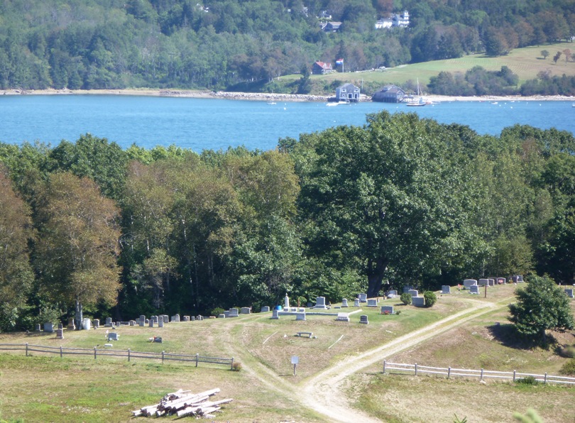 Cemetery, road, with woods and water behind