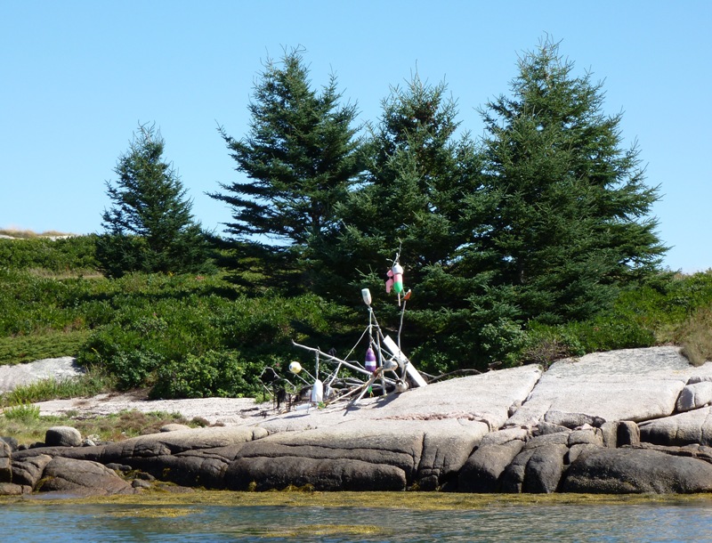 Sticks and buoys that someone tried to turn into a piece of art on a big rock