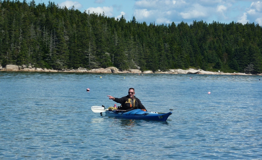 Vince in his kayak, pointing at something