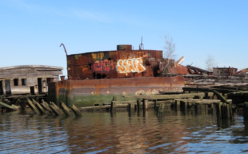 Non-poetic graffiti on side of rusty metal