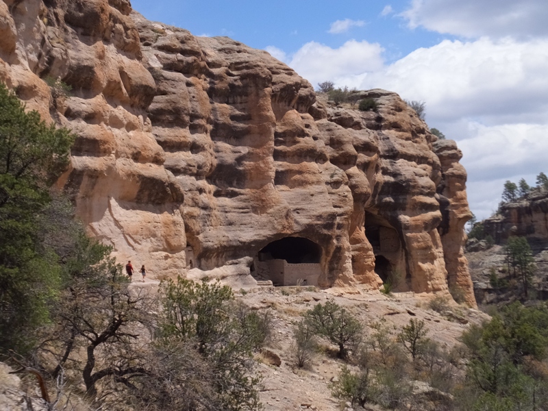 Two people walking to the dwellings; view zoomed out