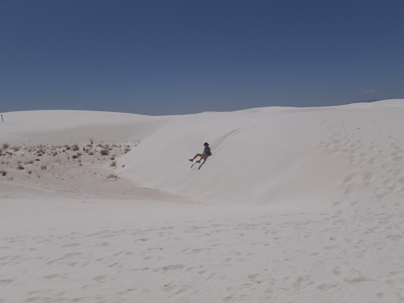 Carmen sliding down a dune on her butt