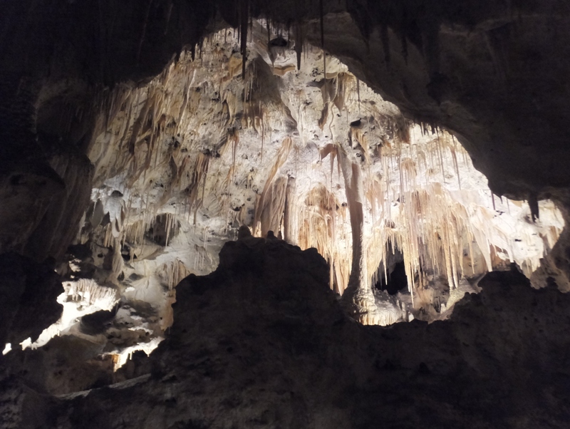 Big illuminated section of cave with lots of stalactites