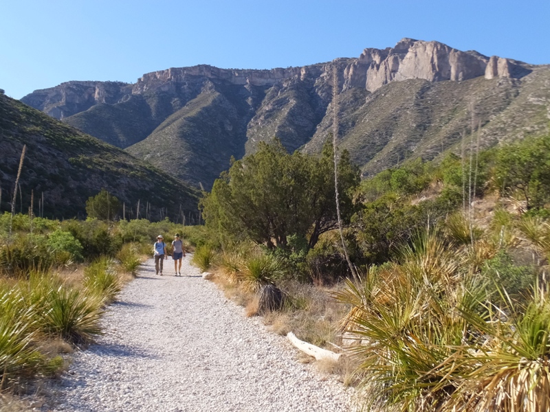 Norma and Carmen on a very wide trail with mountains behind