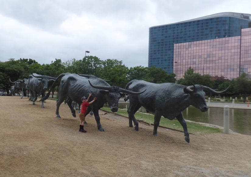 Luke standing by longhorn cattle statues