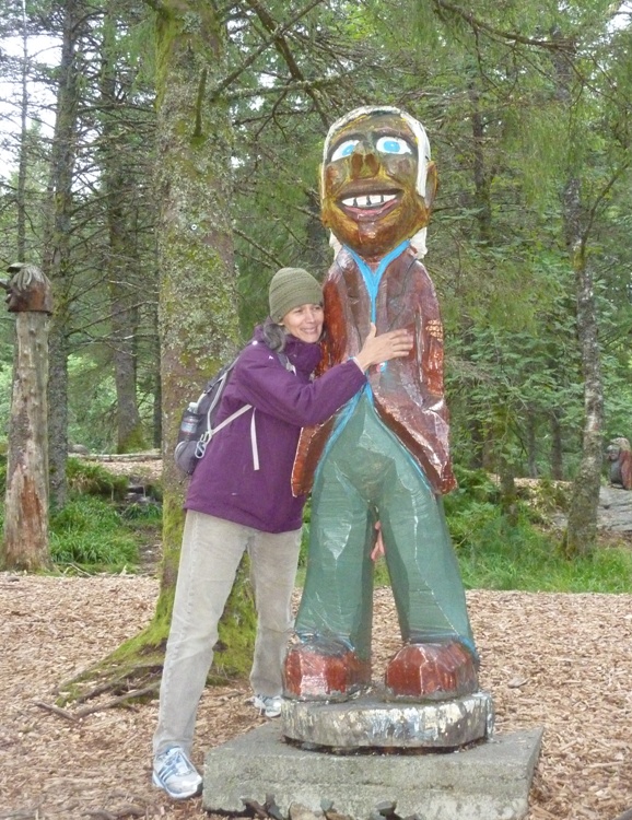 Carmen hugging a wooden troll statue