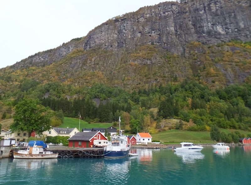 Rugged cliffs by houses and boats