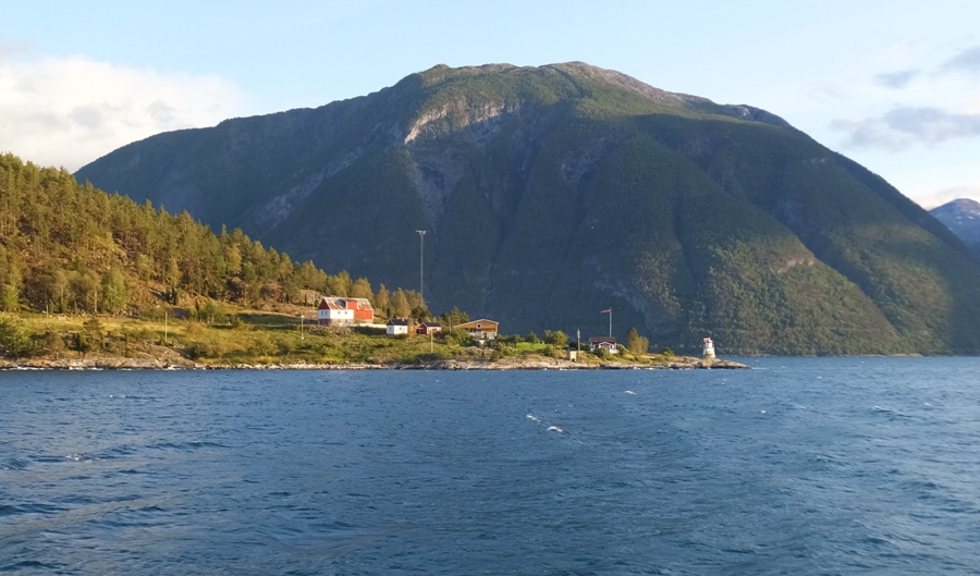 Peninsula illuminated by the sun with dark mountain behind