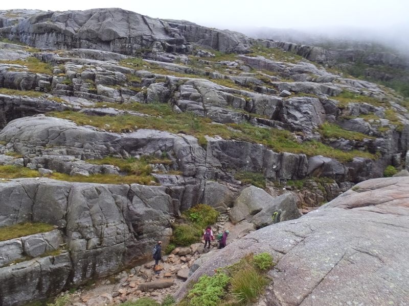 Layered rocks with hikers below