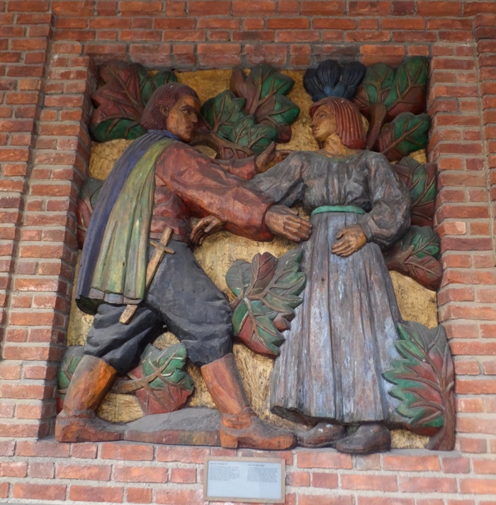 A wood carving of a man and woman