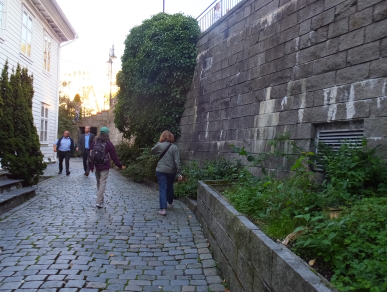 Carmen and Norma walking on cobblestone next to stone wall