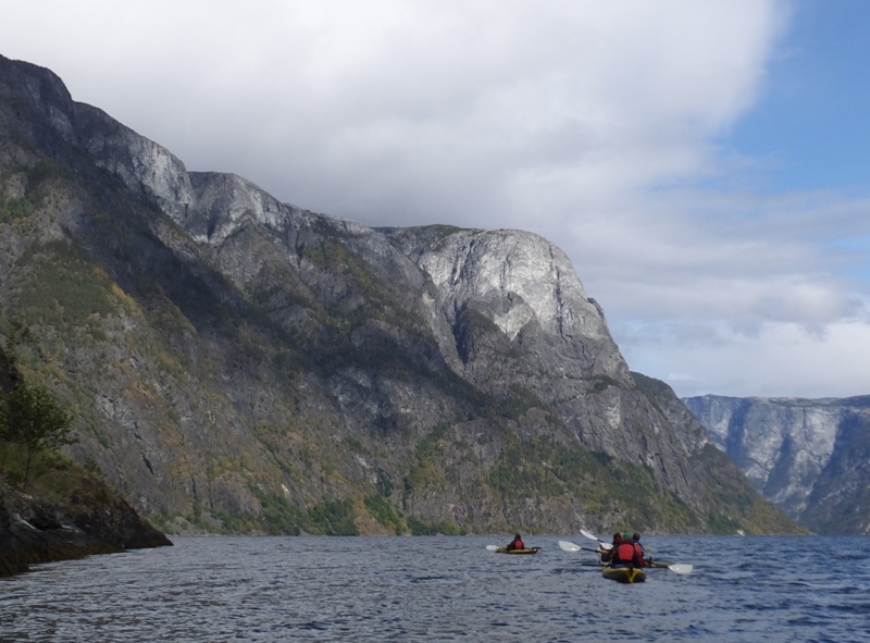 Kayaks and rugged mountains with their tops lacking trees