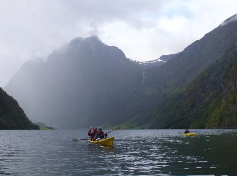 Norma and Carmen kayaking with a mountain in the background capped with snow