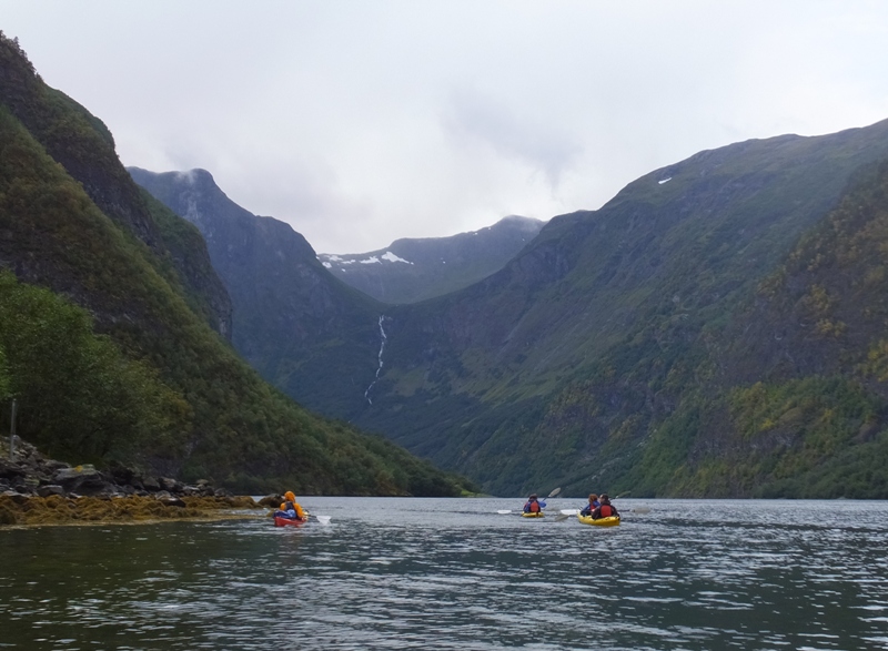 Kayakers with mountain in the background capped with snow