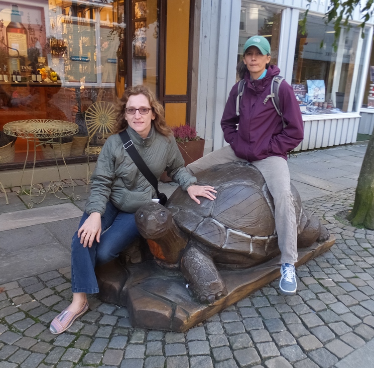 Norma and Carmen on wooden turtle sculpture