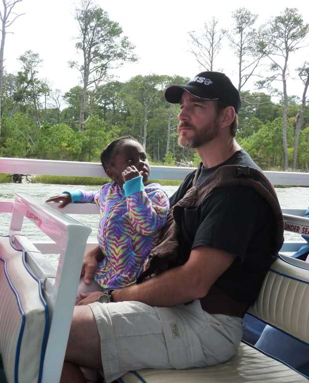 Jimmy in boat with his daughter watching him