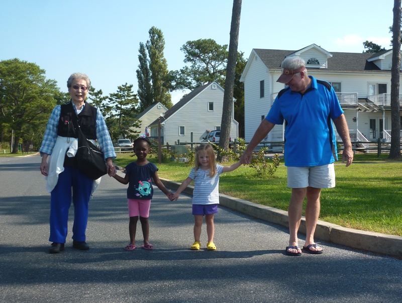 Mom, two kids, and another adult walking, all holding hands