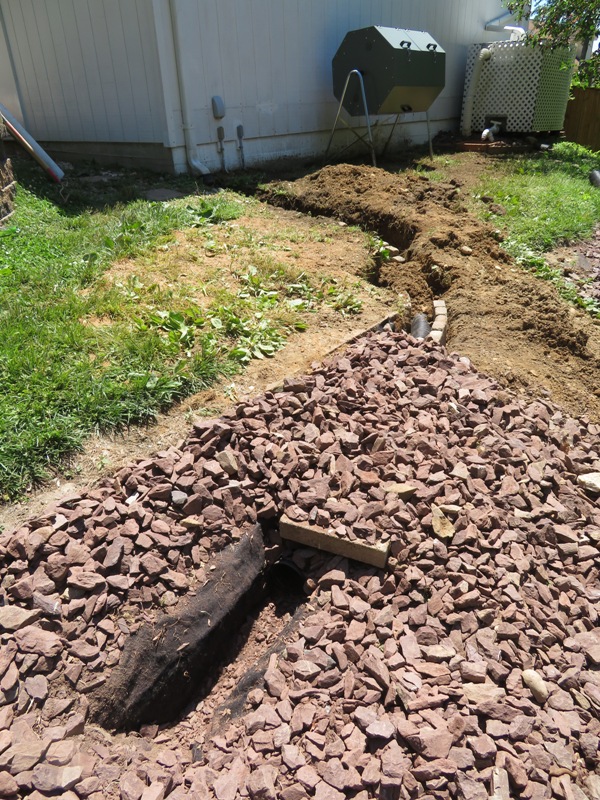 Rock area where water is being diverted from the north side of the garage