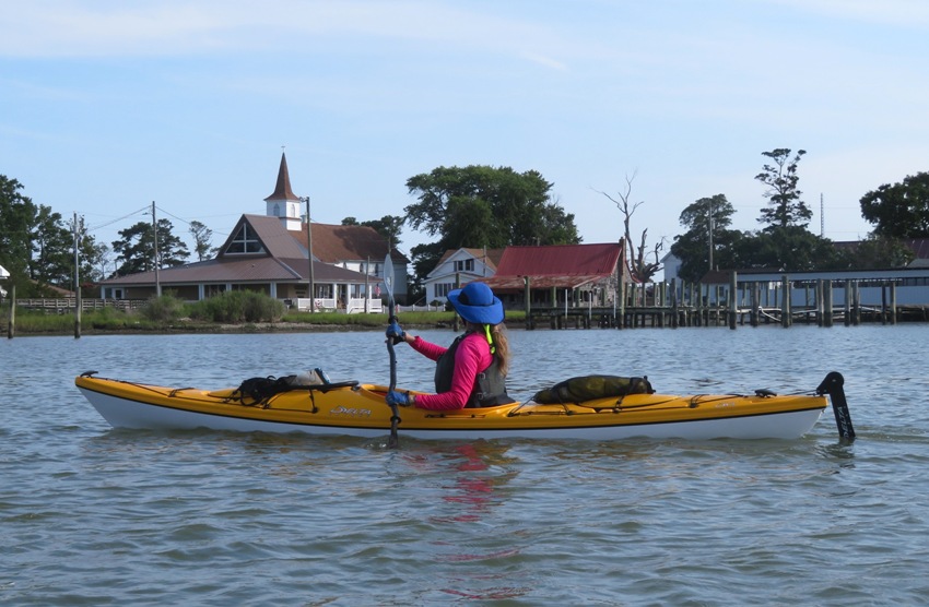 Kayaker in yellow boat looking at church